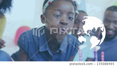 Girl wearing denim shirt, headband blowing candles in dining room, with cake and world map overlay Girl wearing denim shirt, headband blowing candles in dining room, with cake and world map overlay 135086493