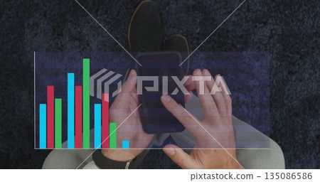 Man tapping smartphone in living room, with smartwatch and multicolored bar chart overlay 135086586
