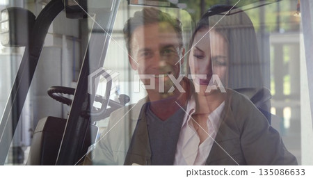 Collaborating colleagues wearing work attire reviewing order in warehouse, with forklift and tablet Collaborating colleagues wearing work attire reviewing order in warehouse, with forklift and tablet 135086633