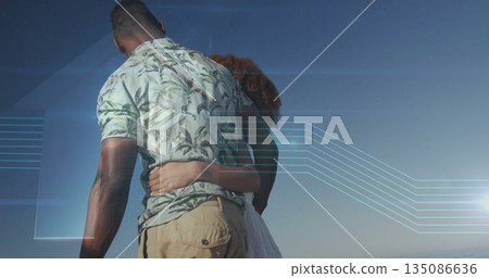 Standing couple holding waists at water's edge, with botanical shirt white dress and digital lines 135086636