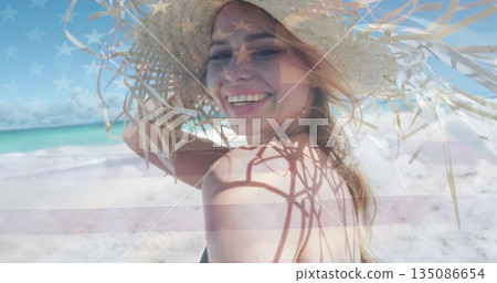 Standing female on tropical beach, straw sun hat, black swimwear top, stars-and-stripes overlay Standing female on tropical beach, straw sun hat, black swimwear top, stars-and-stripes overlay 135086654