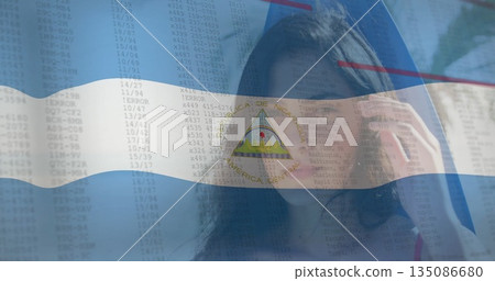 Adjusting female call center agent wearing headset at office with Nicaragua flag and code overlay 135086680