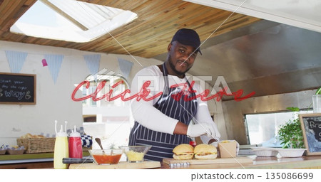 Male cook preparing burgers and arranging trays in food truck kitchen, with chalkboard menu sign Male cook preparing burgers and arranging trays in food truck kitchen, with chalkboard menu sign 135086699