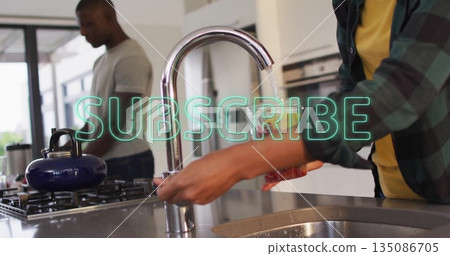 Woman in green shirt washing dish under running faucet at steel sink in kitchen, copy space Woman in green shirt washing dish under running faucet at steel sink in kitchen, copy space 135086705