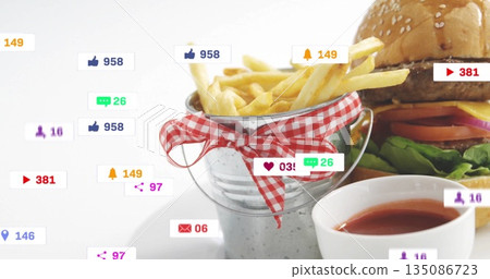 Displaying galvanized bucket holding golden French fries on tabletop, with burger and social icons Displaying galvanized bucket holding golden French fries on tabletop, with burger and social icons 135086723