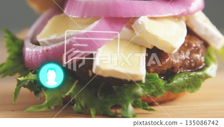 Displaying gourmet burger with cheese and onion rings on wooden board, with comment interface icons Displaying gourmet burger with cheese and onion rings on wooden board, with comment interface icons 135086742