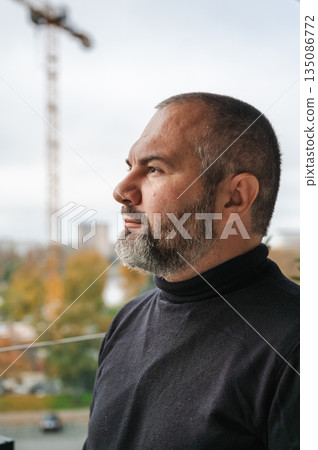 A senior mature European man standing on a hotel balcony, enjoying the outdoor view. Relaxed vacation atmosphere, casual clothing, gentle natural daylight, scenic city, calm expression, short well A senior mature European man standing on a hotel balcony, enjoying the outdoor view. Relaxed vacation atmosphere, casual clothing, gentle natural daylight, scenic city, calm expression, short well 135086772