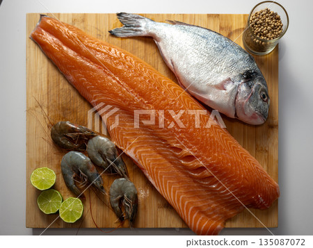 Healthy seafood assortment featuring fresh salmon, dorado, and shrimps. Clean, nutritious food concept with natural ingredients rich in protein and omega-3. Healthy seafood assortment featuring fresh salmon, dorado, and shrimps. Clean, nutritious food concept with natural ingredients rich in protein and omega-3. 135087072