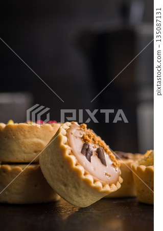 Sweet mini tartlets on black table. Sweet mini tartlets on black table. 135087131