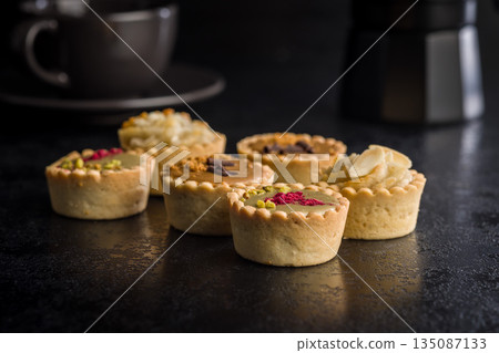 Sweet mini tartlets on black table. Sweet mini tartlets on black table. 135087133