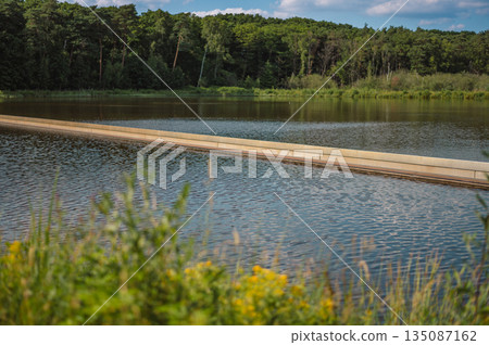 Unique cycling path in Bokrijk, Belgium, where the trail cuts through a pond, giving the illusion of riding across water. 135087162