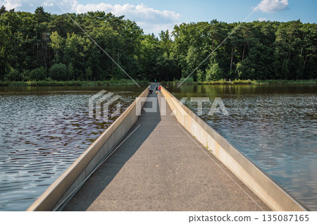Unique cycling path in Bokrijk, Belgium, where the trail cuts through a pond, giving the illusion of riding across water. Unique cycling path in Bokrijk, Belgium, where the trail cuts through a pond, giving the illusion of riding across water. 135087165