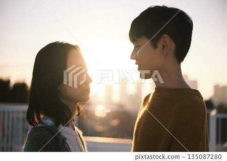 黃昏時分，一對情侶在屋頂上。 135087280