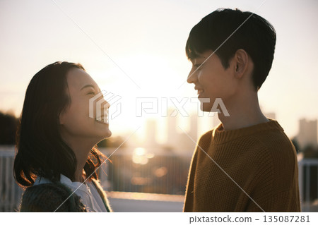 黃昏時分，一對情侶在屋頂上。 135087281
