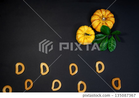 Crispy small dry bread bagels scattered on a black background. Minimalistic snack food composition highlighting simple texture, contrast, and bakery concept. Crispy small dry bread bagels scattered on a black background. Minimalistic snack food composition highlighting simple texture, contrast, and bakery concept. 135087367