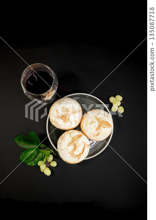 Autumn still life with pumpkins and homemade freshly baked buns arranged on a black background. Warm rustic mood, seasonal harvest, cozy food concept. 135087718