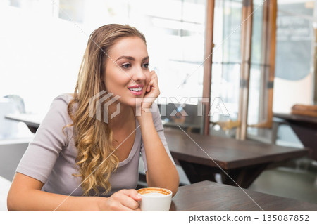 Woman gazing right while holding mug at cafe table with glass partitions near windows, copy space Woman gazing right while holding mug at cafe table with glass partitions near windows, copy space 135087852
