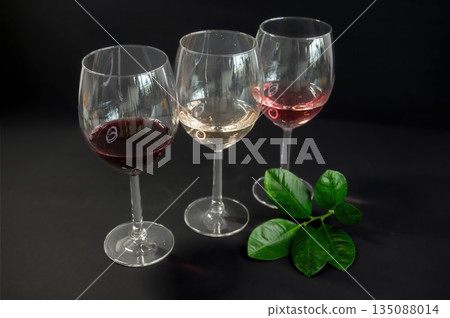 Elegant row of three empty wine glasses on a black background. Minimalistic, reflective glassware composition with clean lines and moody lighting. Perfect for wine, bar, and restaurant concepts. Elegant row of three empty wine glasses on a black background. Minimalistic, reflective glassware composition with clean lines and moody lighting. Perfect for wine, bar, and restaurant concepts. 135088014