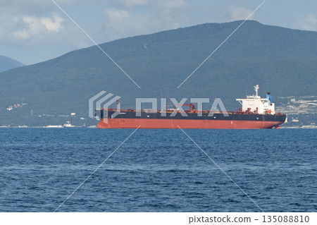 August 24, 2025: Large cargo ship entering the port of Novorossiysk, Russia, on the Black Sea, illustrating maritime transport, industrial shipping and coastal infrastructure August 24, 2025: Large cargo ship entering the port of Novorossiysk, Russia, on the Black Sea, illustrating maritime transport, industrial shipping and coastal infrastructure 135088810