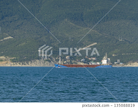 August 24, 2025: Large cargo ship entering the port of Novorossiysk, Russia, on the Black Sea, illustrating maritime transport, industrial shipping and coastal infrastructure August 24, 2025: Large cargo ship entering the port of Novorossiysk, Russia, on the Black Sea, illustrating maritime transport, industrial shipping and coastal infrastructure 135088819