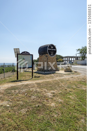 August 24, 2025: Genre sculpture of a barrel with winery sign in Myskhako, Russia, with the sea and mountains on the horizon, symbolizing local winemaking, tourism and coastal landscape 135088831
