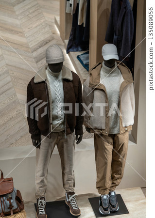 Winter Fashion Display: Two Mannequins in Neutral Tones With Jackets and Knitwear 135089056