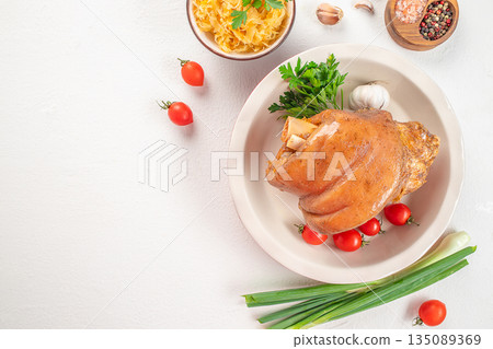 Roasted pork knuckle with vegetables on white background 135089369
