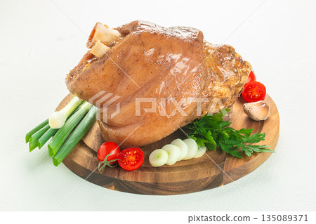 Roasted pork knuckle with fresh vegetables on cutting board Roasted pork knuckle with fresh vegetables on cutting board 135089371