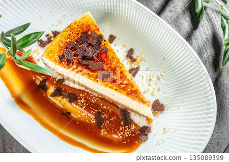 slice of caramel cheesecake with chocolate crumbs on white plate top view slice of caramel cheesecake with chocolate crumbs on white plate top view 135089399