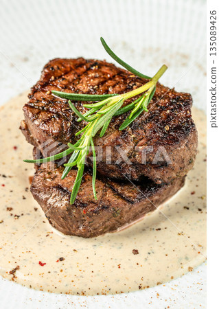 Grilled beef steak with creamy pepper sauce and rosemary on a white plate 135089426