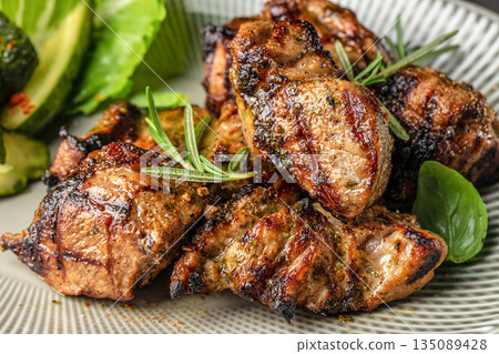 Grilled meat pieces with herbs and fresh vegetables on a plate Grilled meat pieces with herbs and fresh vegetables on a plate 135089428