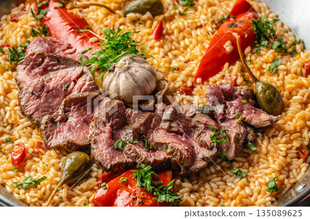Close-up of paella with beef, peppers, and garlic. top view. 135089625