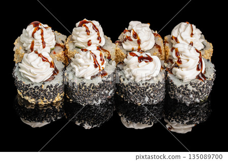 Decorative sushi rolls topped with swirls of creamy sauce and drizzled with soy glaze are beautifully coated in black and white sesame seeds Decorative sushi rolls topped with swirls of creamy sauce and drizzled with soy glaze are beautifully coated in black and white sesame seeds 135089700