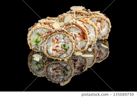 Crunchy sushi rolls filled with creamy cheese, cucumber, and seafood are coated in golden tempura, drizzled with sauce, and garnished with almond slices on a glossy black surface Crunchy sushi rolls filled with creamy cheese, cucumber, and seafood are coated in golden tempura, drizzled with sauce, and garnished with almond slices on a glossy black surface 135089730