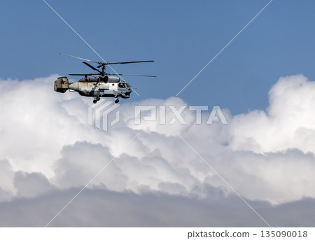 August 21, 2025: Novorossiysk, Russia: Ka-27 military helicopter flying in the sky against clouds, illustrating naval aviation, air patrol and defense activity on the Black Sea coast 135090018