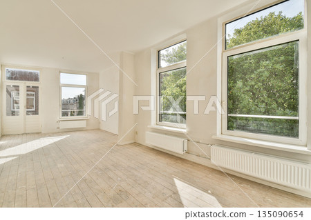 Spacious room with large windows allowing natural light, featuring minimalist decor and light-colored walls, creating an inviting atmosphere. Spacious room with large windows allowing natural light, featuring minimalist decor and light-colored walls, creating an inviting atmosphere. 135090654