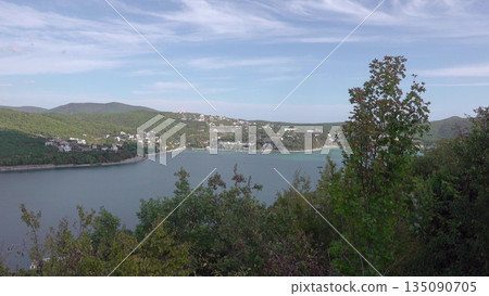 The promenade along Lake Abrau-Dyurso with calm water, greenery, and scenic surroundings 135090705