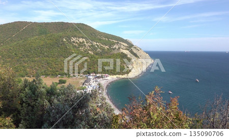 Scenic view of Durso beach with clear sea and mountain landscape, showcasing natural coastline, summer atmosphere and peaceful seaside environment in southern Russia Scenic view of Durso beach with clear sea and mountain landscape, showcasing natural coastline, summer atmosphere and peaceful seaside environment in southern Russia 135090706