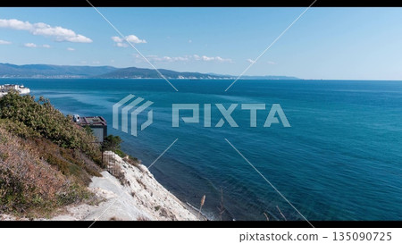 View of Tsemesskaya Bay from Mount Koldun in Myskhako near Novorossiysk, Russia, overlooking the Black Sea coastline, port area and mountainous landscape 135090725