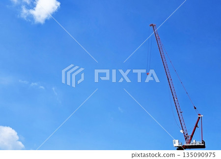 Large Red Construction Crane Against Blue Sky with White Clouds. Large Red Construction Crane Against Blue Sky with White Clouds. 135090975