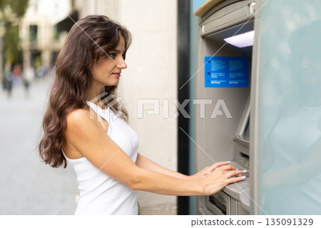 Young woman enters her ATM PIN code 135091329