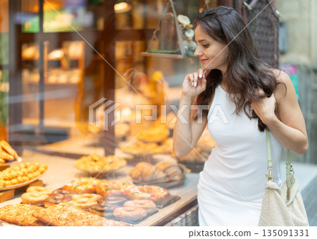 Young woman chooses baked goods in bakery 135091331