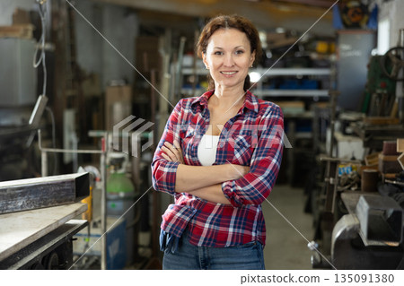 Adult woman posing in oak workshop Adult woman posing in oak workshop 135091380