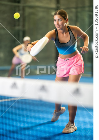 Young and adult women playing doubles tennis 135091396