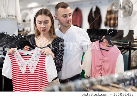 Couple young woman and young man choosing blouse Couple young woman and young man choosing blouse 135091432