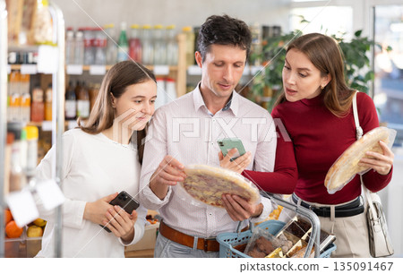 Man woman and girl scans QR code of pizza Man woman and girl scans QR code of pizza 135091467