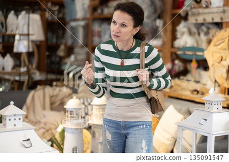 Adult woman choosing furniture in store 135091547