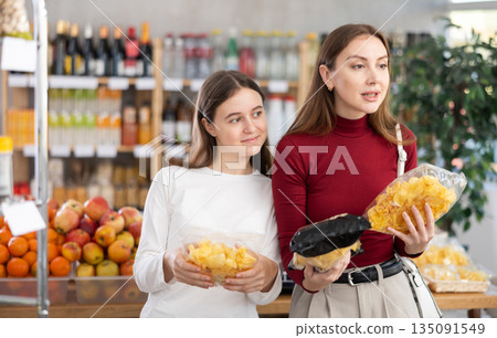 Mom and daughter choose chips Mom and daughter choose chips 135091549