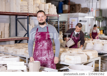 Successful ceramicist standing in pottery slip casting workshop Successful ceramicist standing in pottery slip casting workshop 135091562