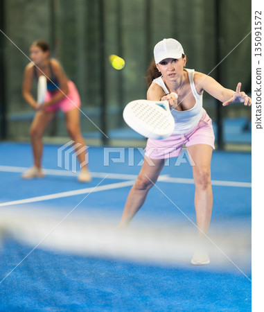 Young and adult women playing doubles tennis Young and adult women playing doubles tennis 135091572